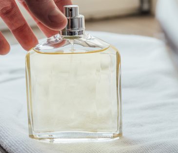 man grabbing cologne bottle