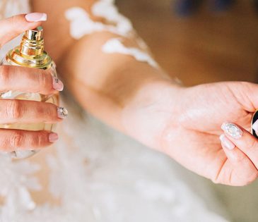 Bride putting perfume on her wrist - close up