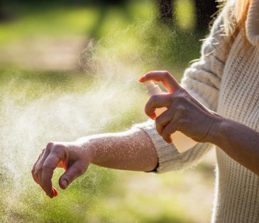 Insect repellent. Woman applying mosquito repellent