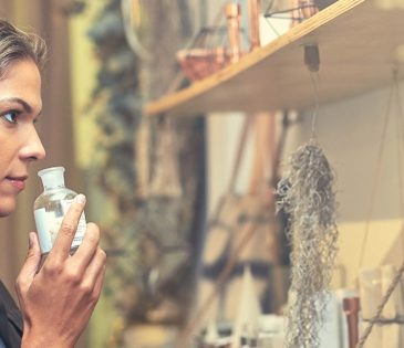 woman smelling perfume in store